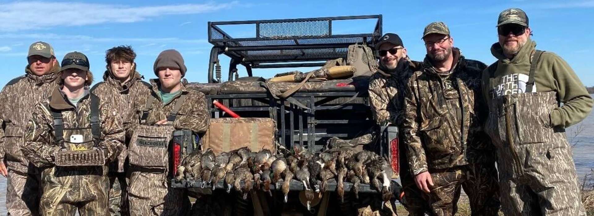 Group of 7 hunters smiling with a large bag of ducks hunted in Arkansas with Ducks N Dogs Hunting Club